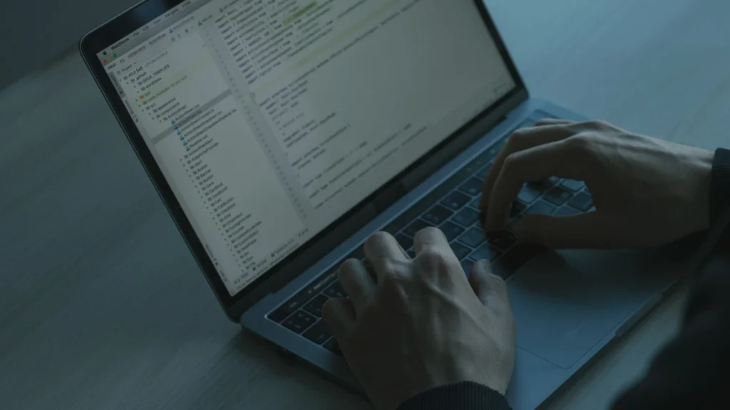 hands typing on a laptop keyboard in a professional workspace