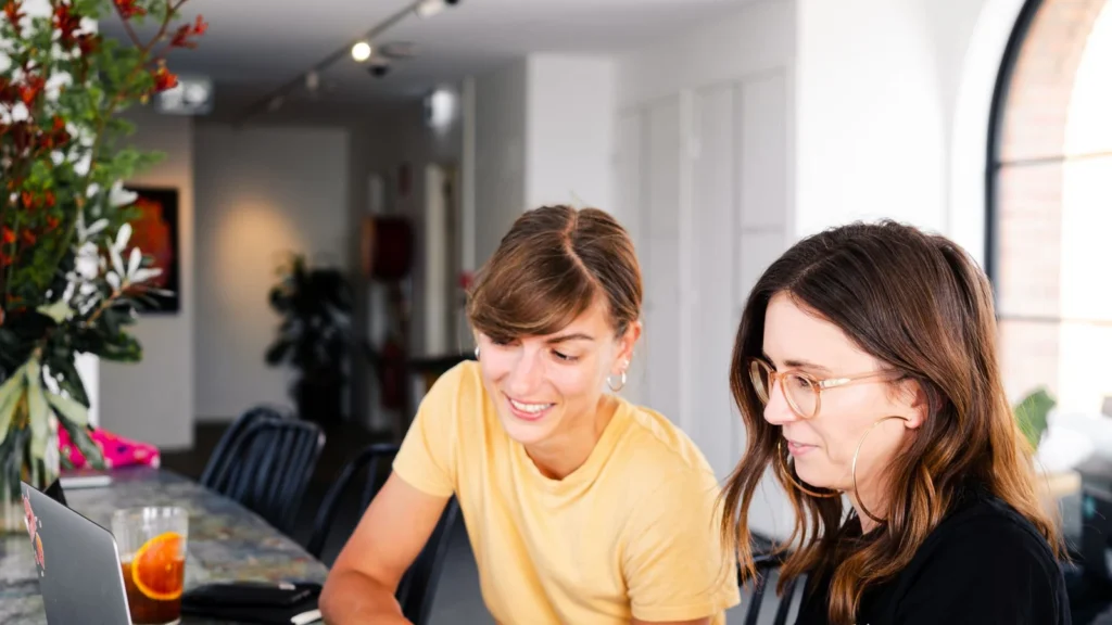 two colleagues reviewing website content together on a laptop