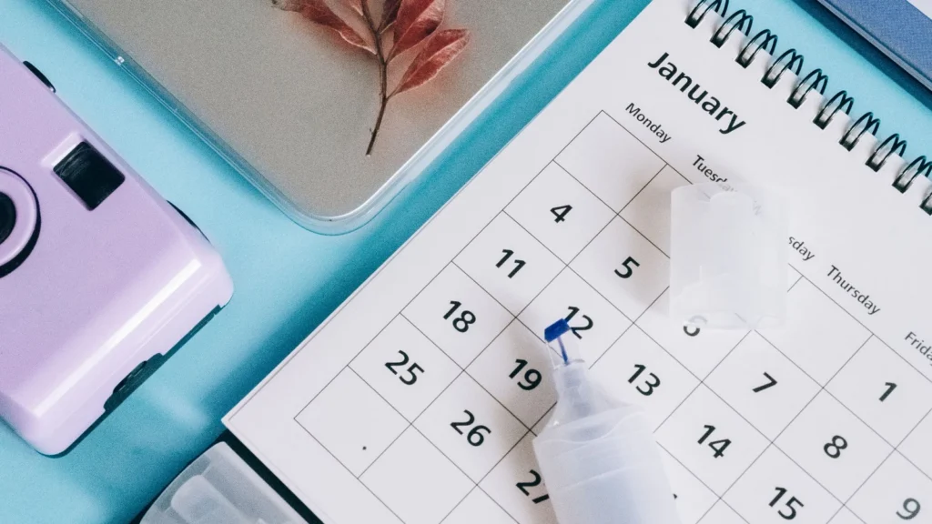 laptop, desk calendar and notebook arranged for booking workflow planning