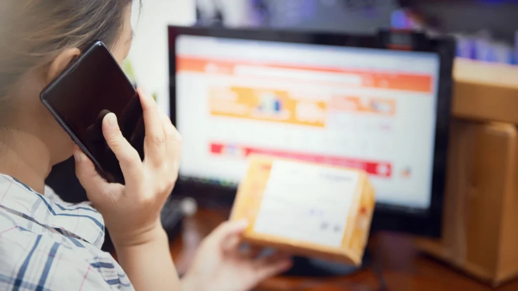 online shopper using a smartphone beside a delivery parcel